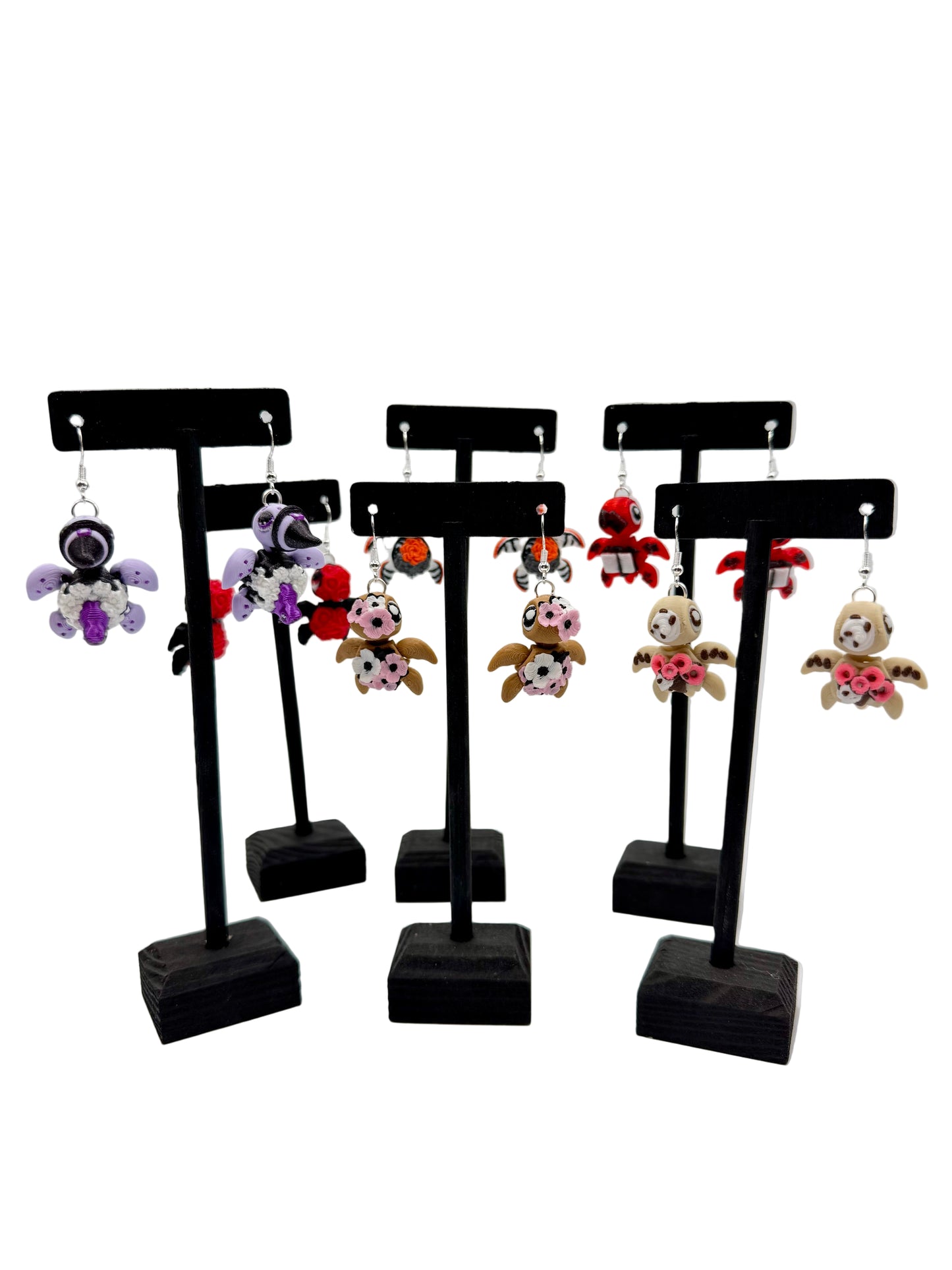 Set of earrings on black stands against a white background